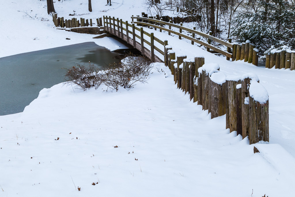 Snow covered bridge over frozen stream, Burns Park, Arkansas